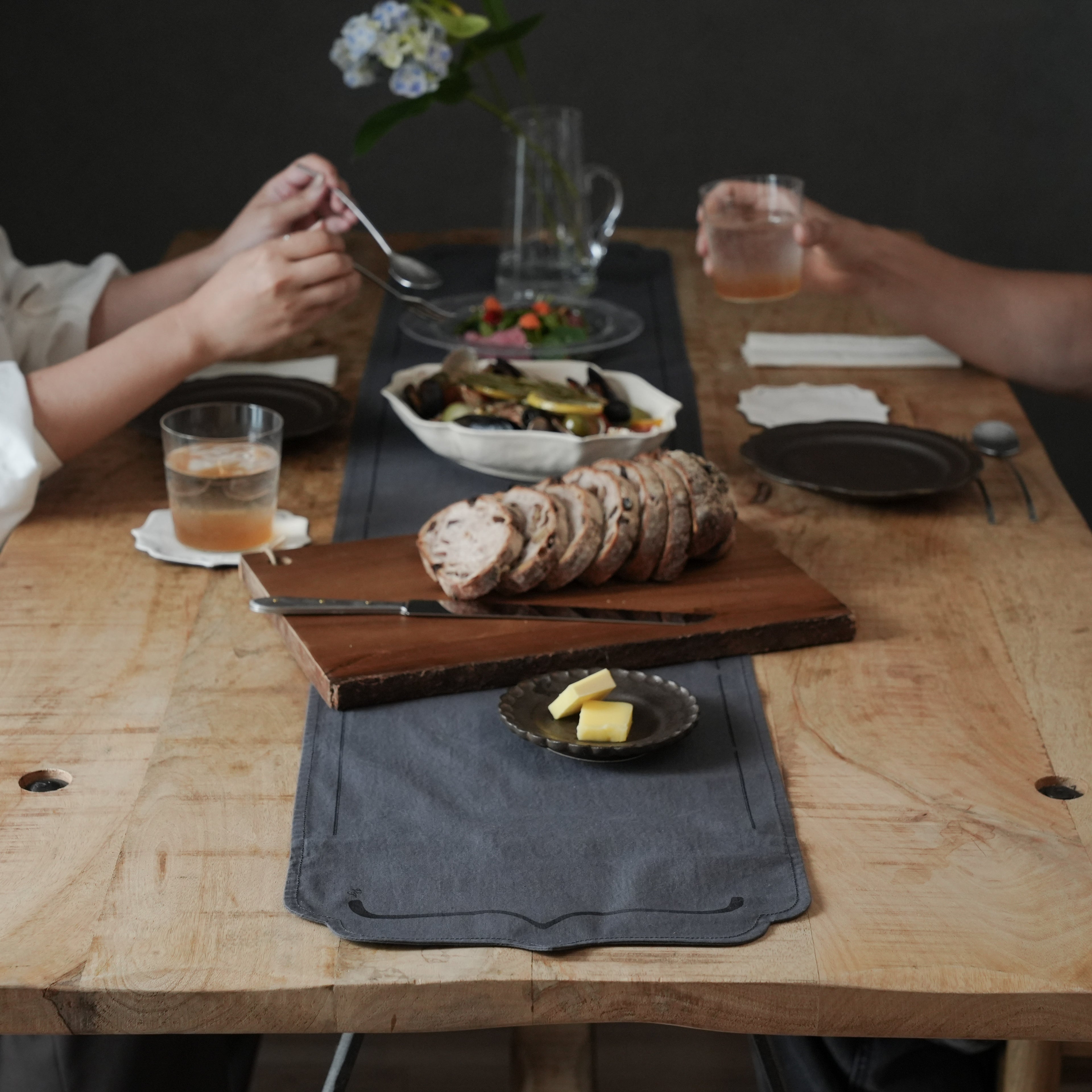 sui.×服とタイポグラフ｛括弧｝のテーブルランナーやコースターを使ったパンとチーズのある食卓